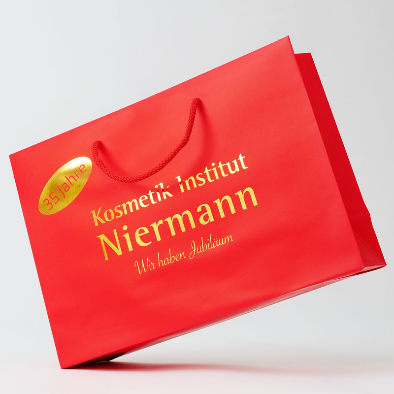 Rote Papiertüte bedruckt mit goldenem Logo