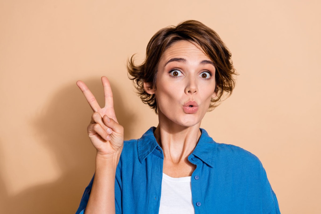 Frau mit Vitor Zeichen für Papiertaschen